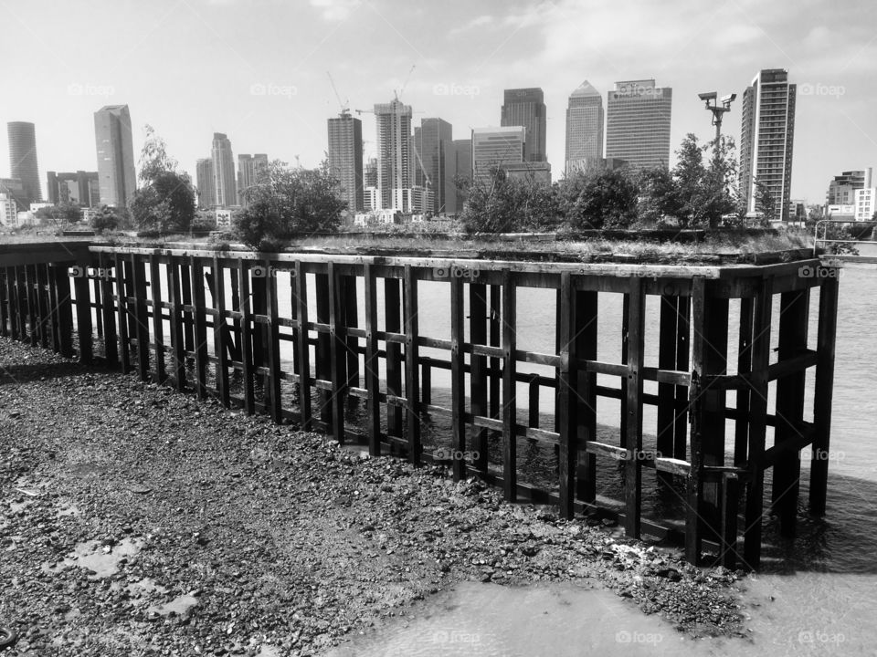 View over a wooden jetty across the River Thames to the Isle of Dogs, from Greenwich Peninsula 