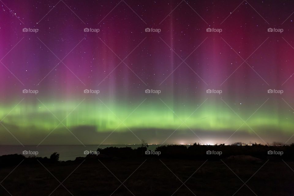 Strong colorful northern light over the ocean in Sweden 