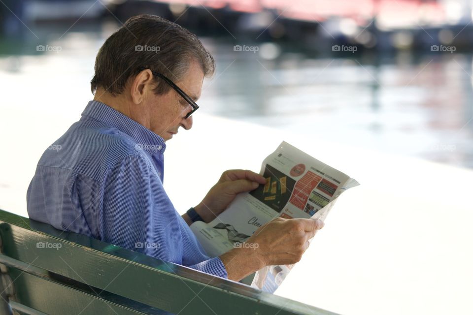 Man Reading A Newspaper In A Park