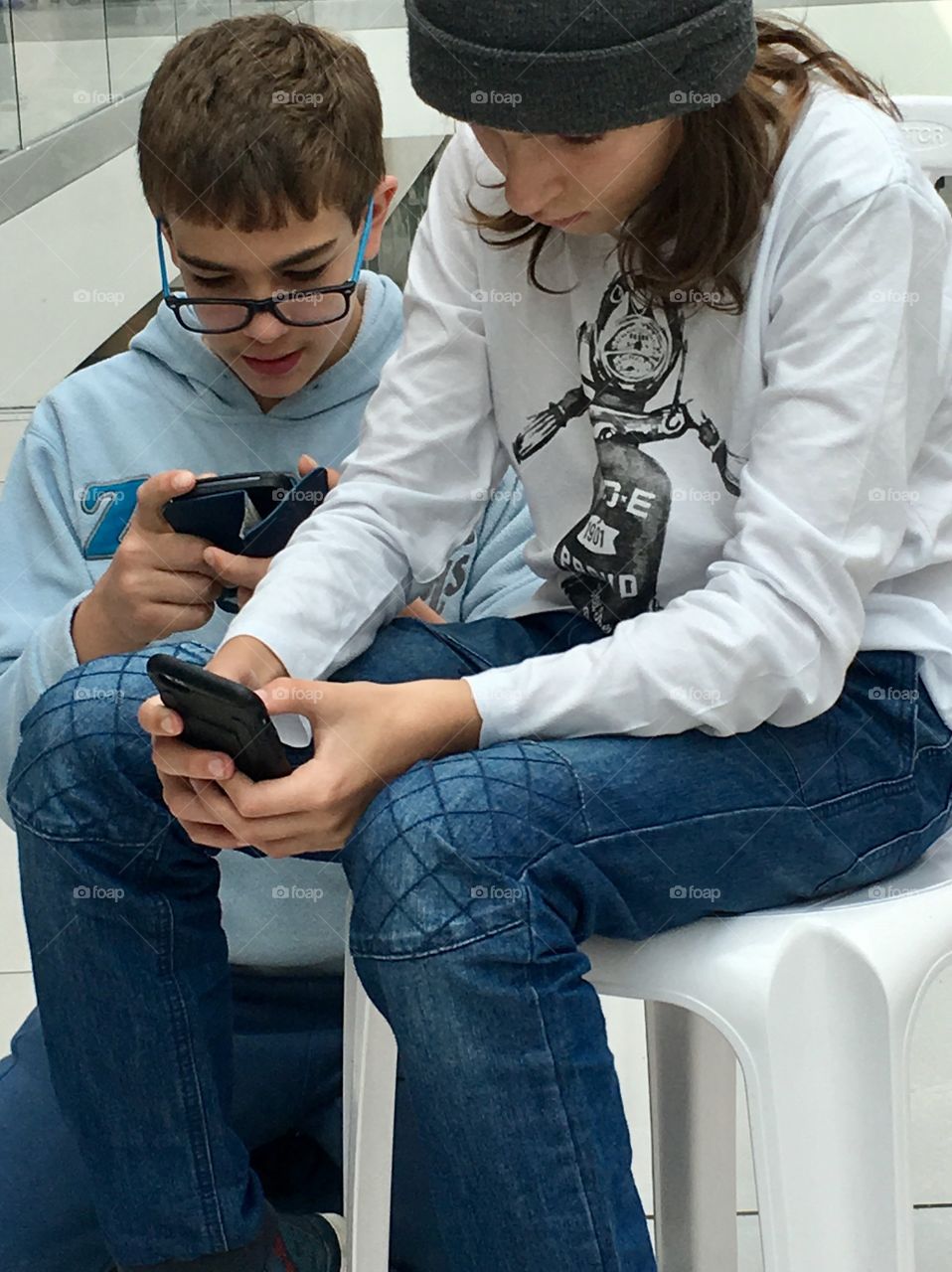 ‏Two kids playing a video game 
‏on smartphone