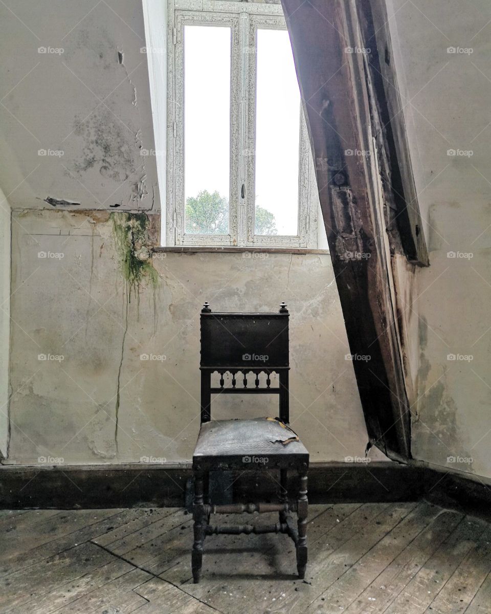 chair in attic of dilapidated house