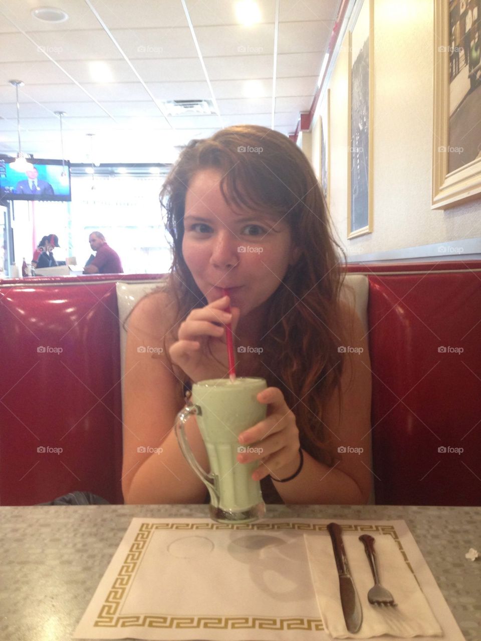 Girl loving a Milkshake . Teenage girl enjoying her milkshake at a diner