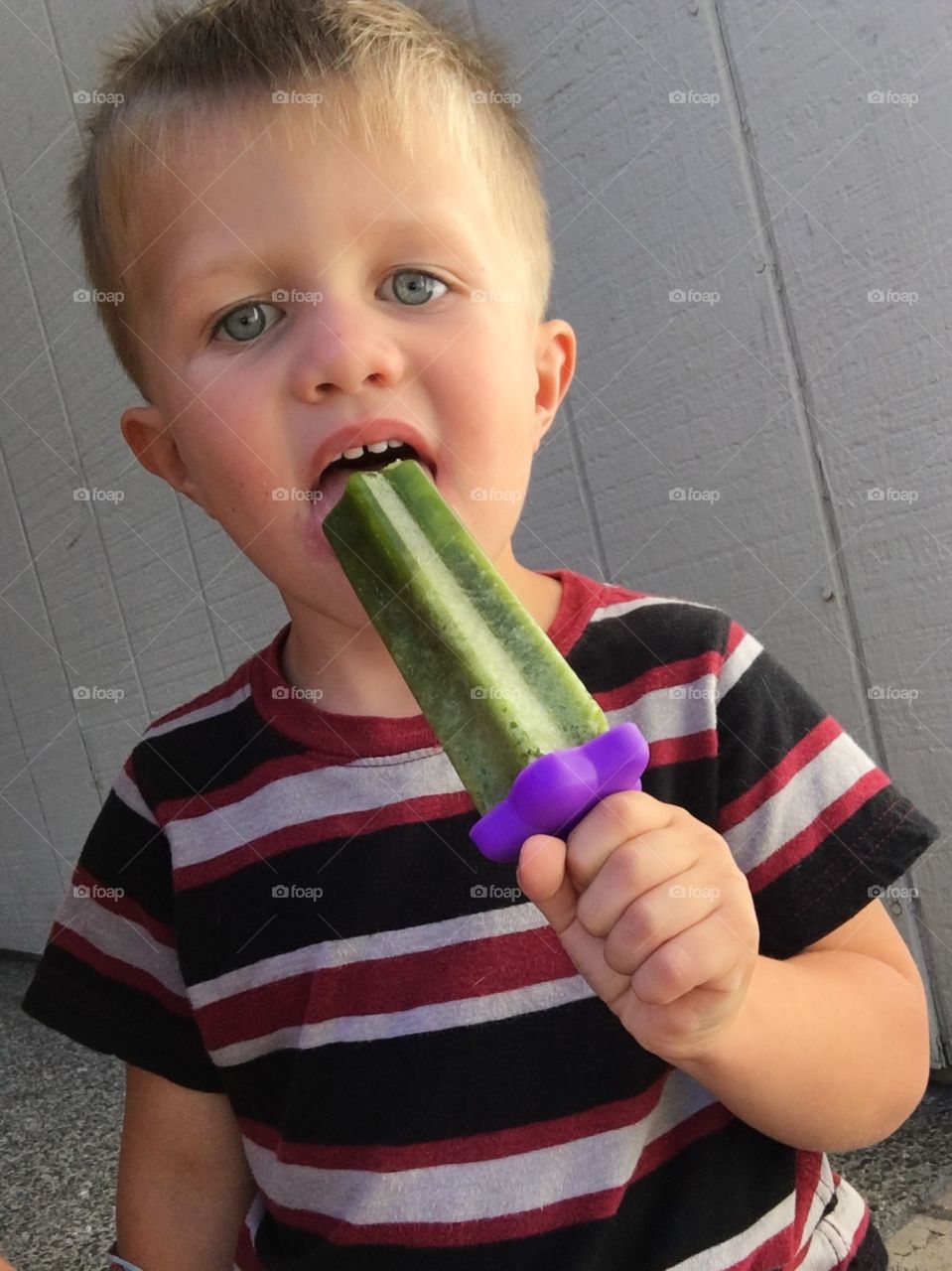 Boy eating a popsicle.