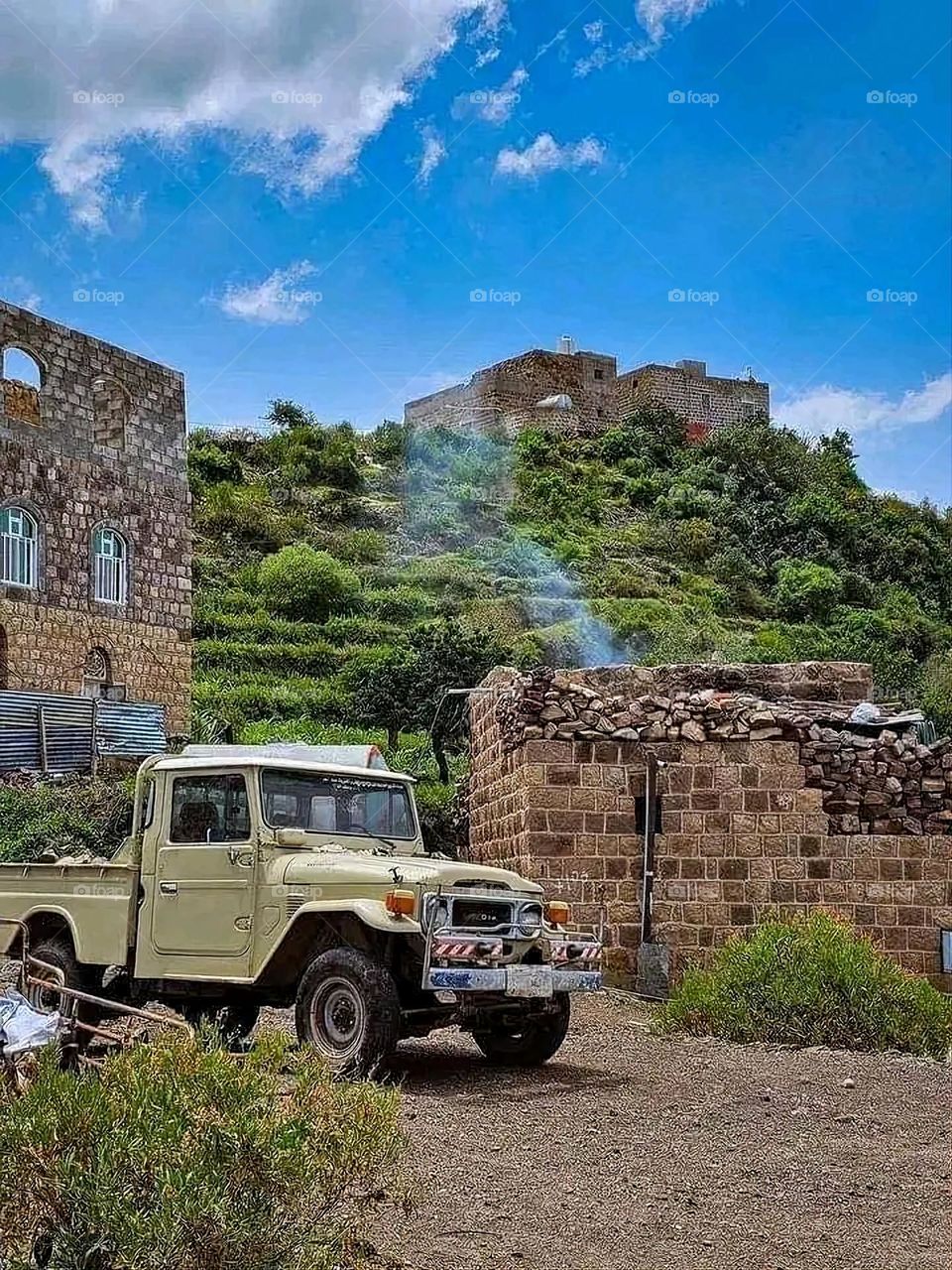 The image embodies a natural natural plate of the mountains of nature, where green agricultural stands are graded on the slopes as if they were lines of a poem, which fog harmoniously wrapped, and clouds hugged them in the mountain knife and the whis