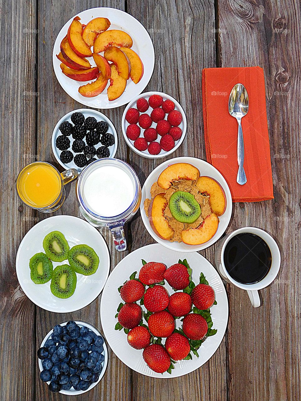A breakfast or lunch fit for a King or Queen! A view from above of a breakfast made from a variety of fresh, colorful fruit. This flat lay consists of strawberries, peaches, kiwi, blackberries, raspberries and blueberries. 