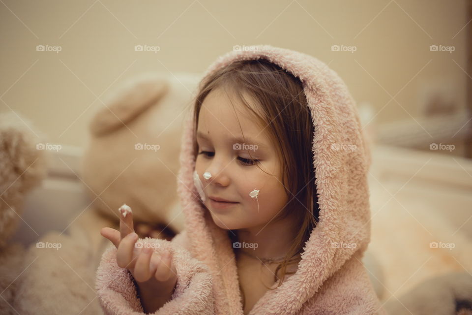 Little sisters in bathrobe with cream