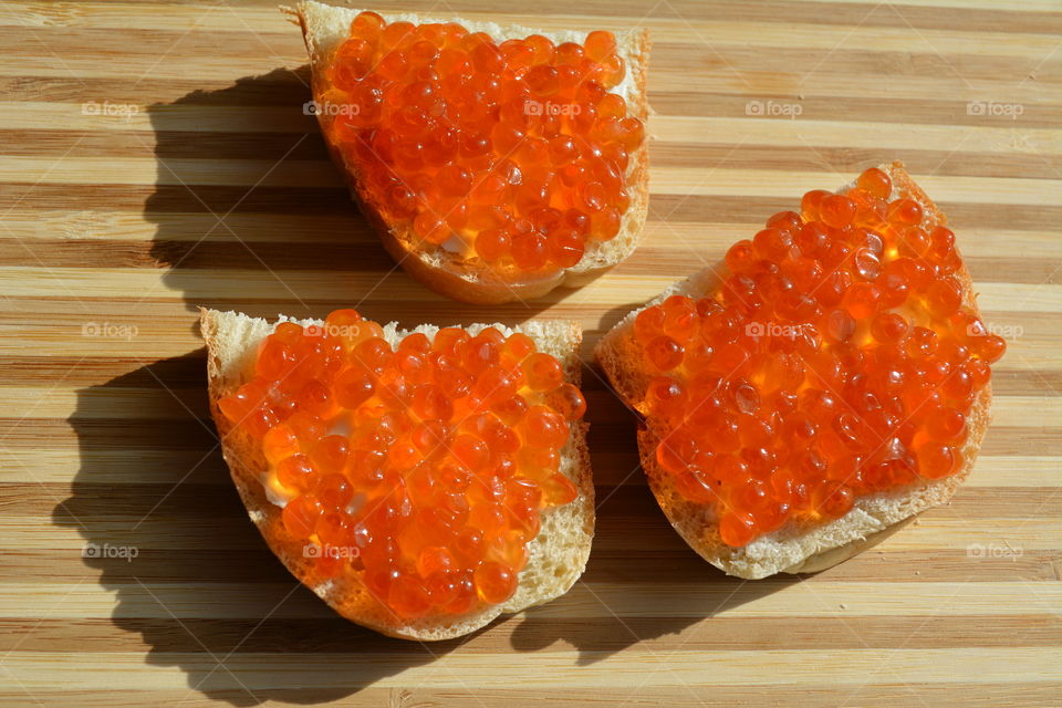 sandwiches with red caviar wood table background