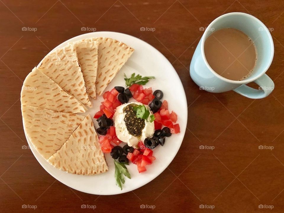 Breakfast.. labneh, black olives, tomatoes, olive oil, zaatar, peta bread and tea
