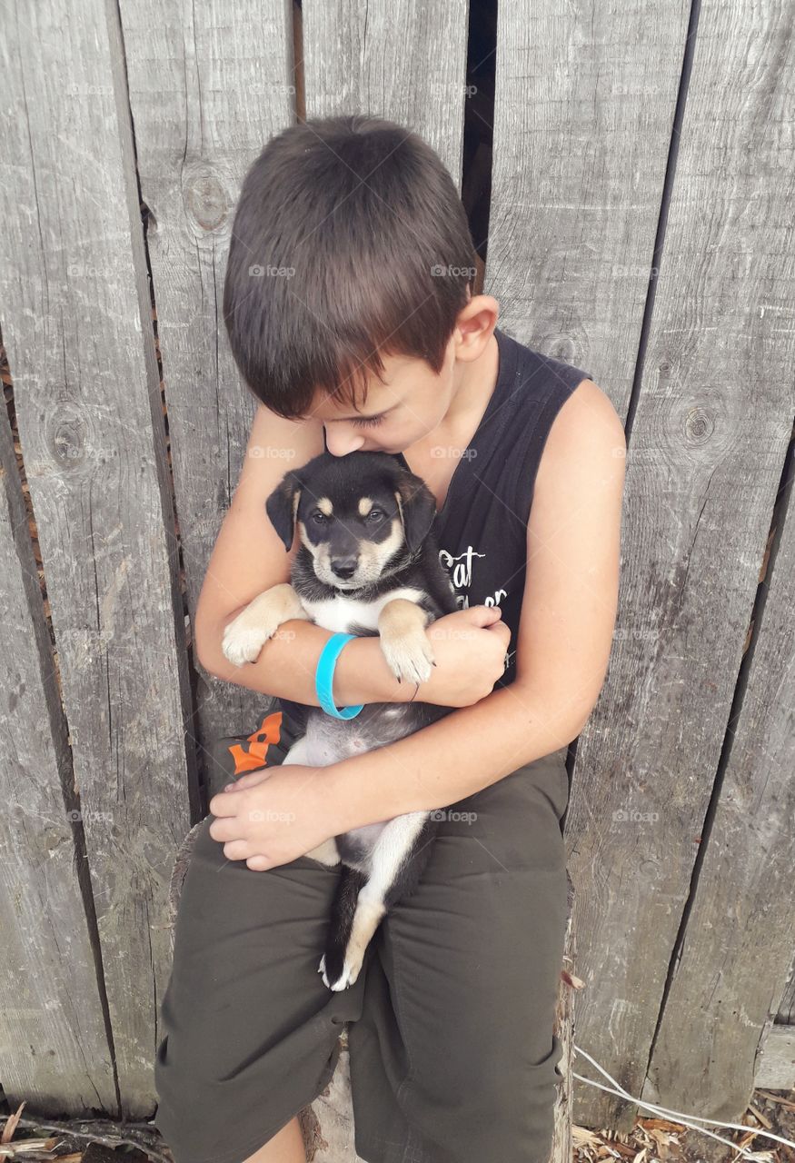 boy kissing a puppy