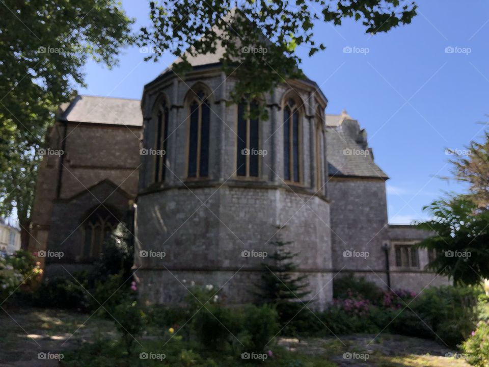 All Saints Church in Torbay surrounded by both brilliant sunshine but by the natural beauty of wild flowers.