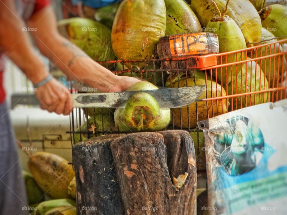 Street Vendor Chopping A Coconut