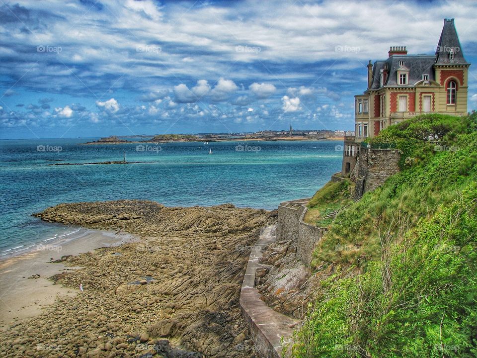 Cliff Top House. A traditional house perched on the edge of a cliff overlooking the ocean.