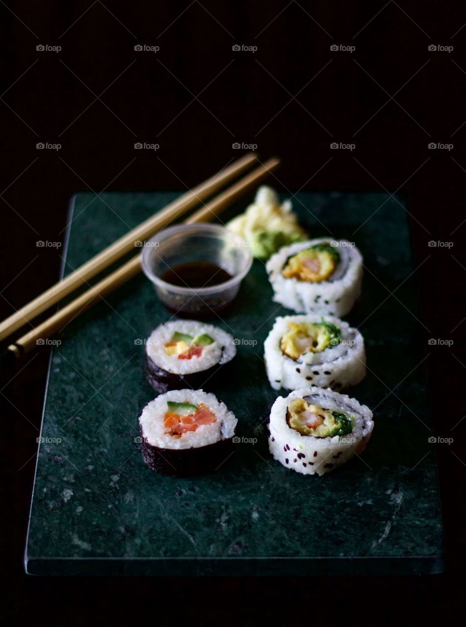 Sushi rolls served on tray with chopping stick in a restaurant