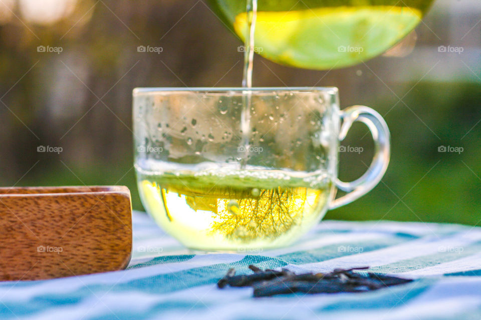 Close-up of pouring green tea in cup
