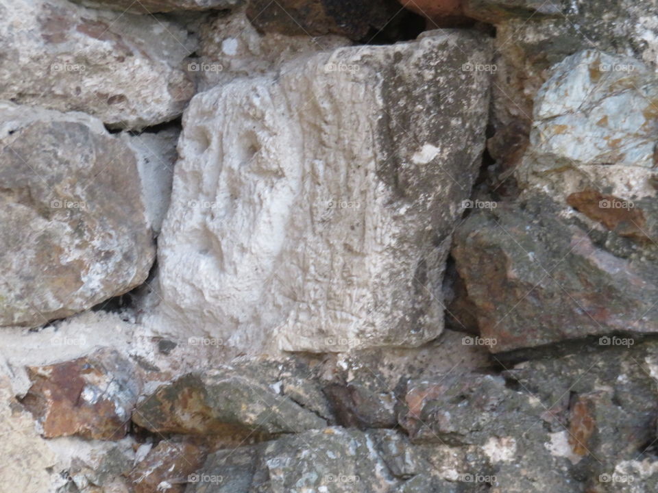 Ancient ramparts ,,sad" face carved in stone
