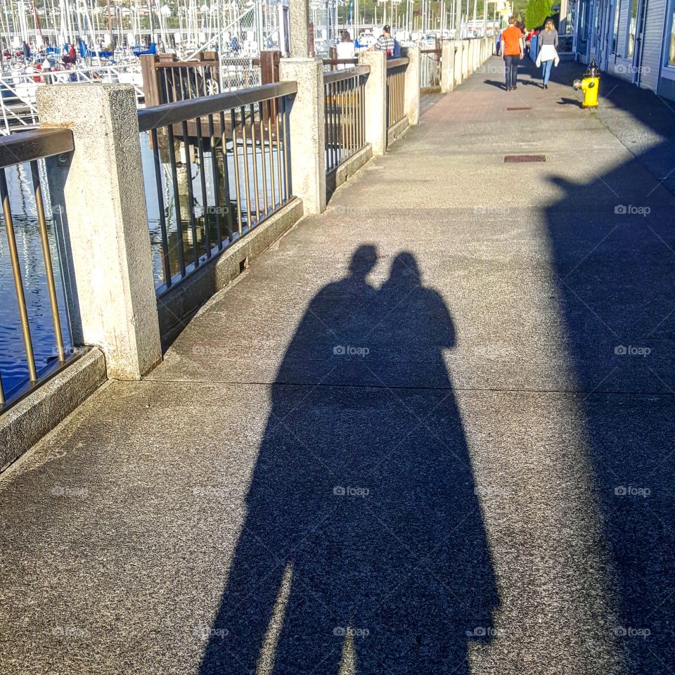Sun is going down, making tall shadows at the marina.