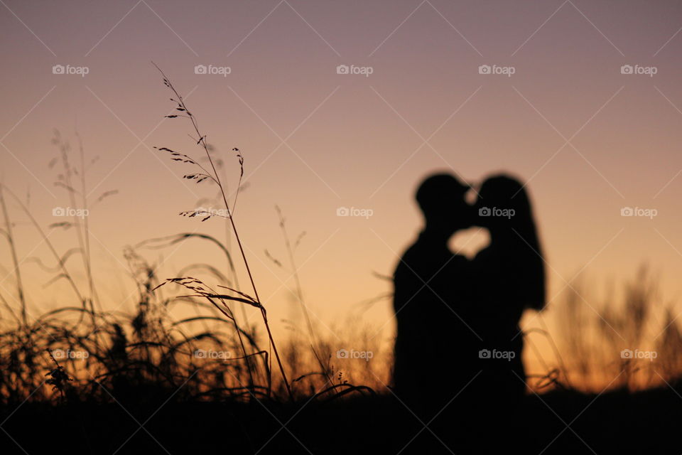 Silhouette of couple kissing at sunset