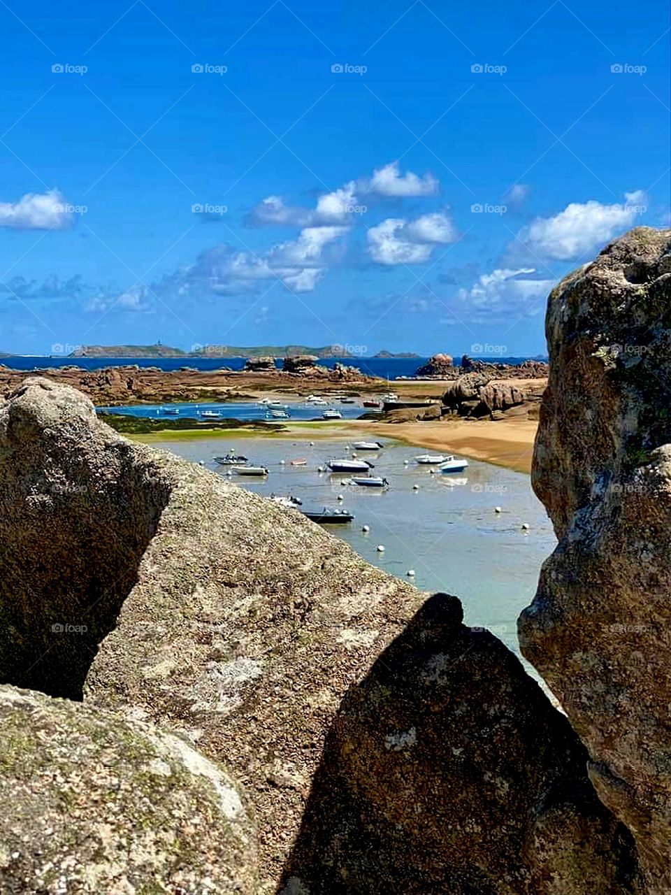 View of the sea, the beach and the boats through the rocks in Trégastel