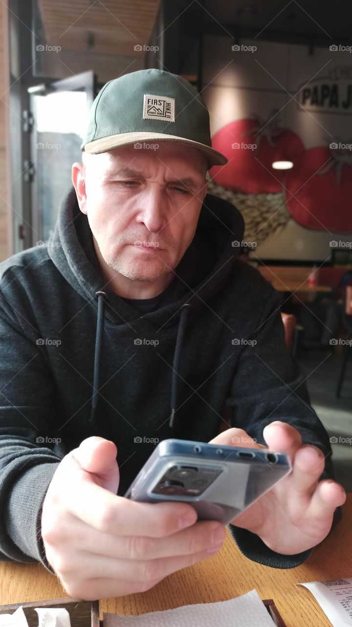 old man in a cap make a call