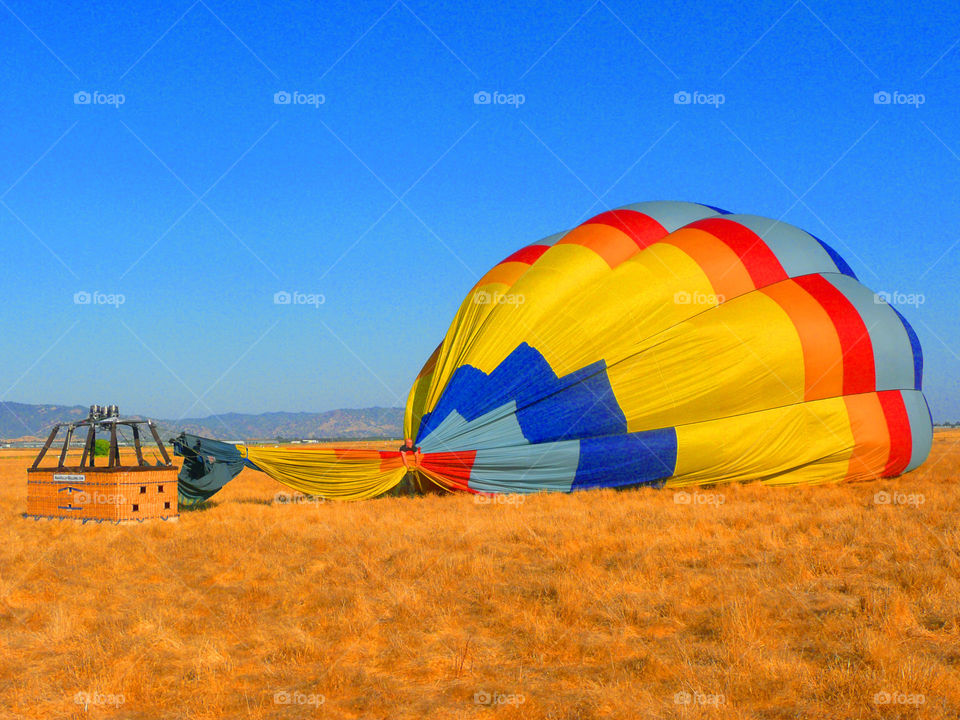 Colorful hot air balloon landing on landscape