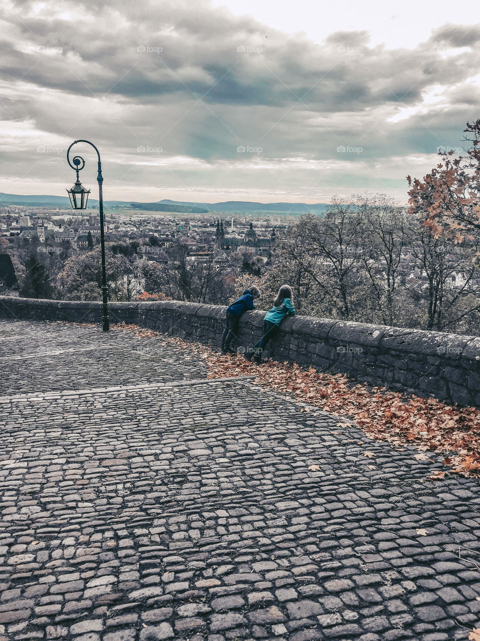 Two children are watching the city view in autumn