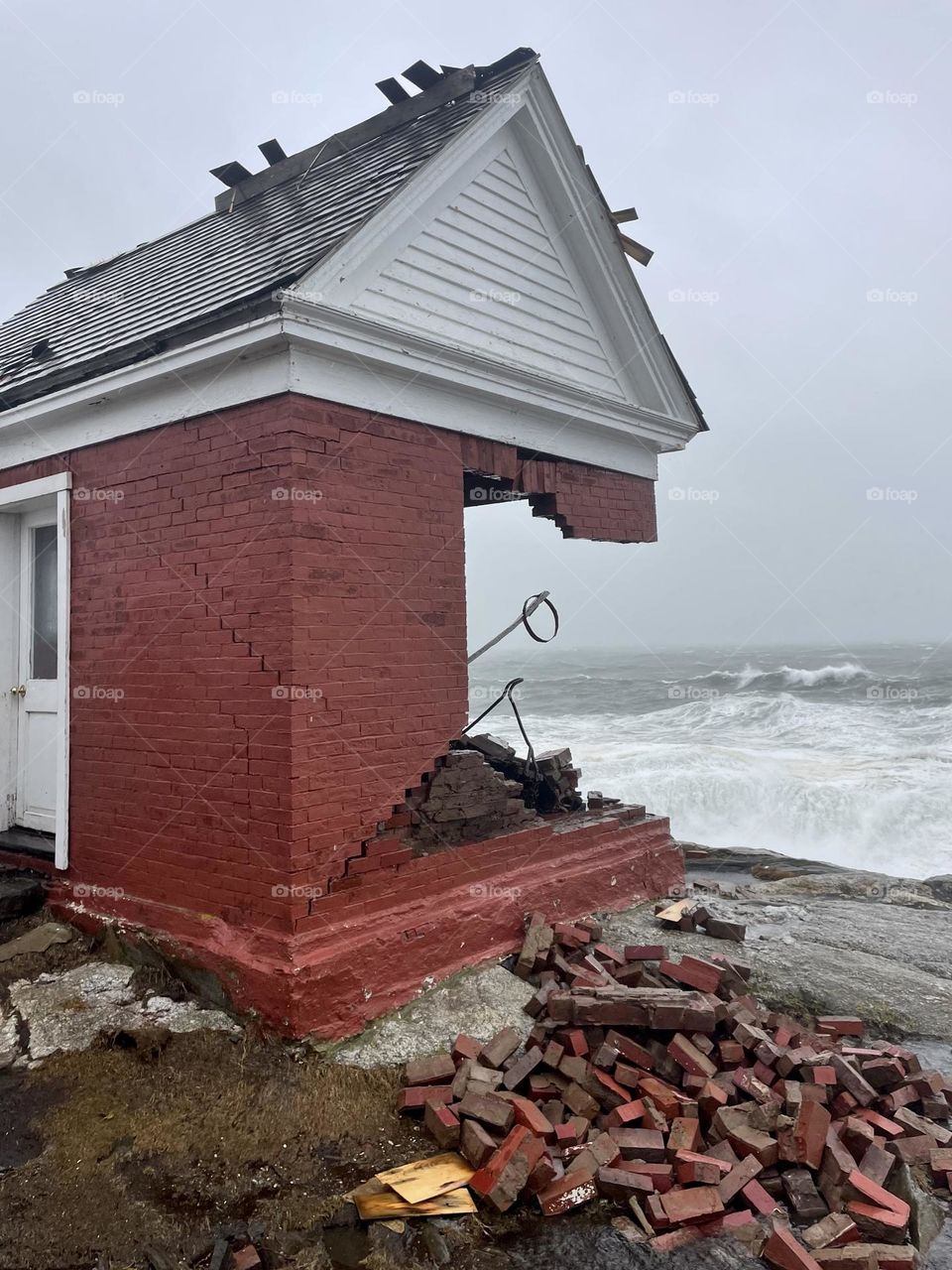 The historic brick Bell House at Pemaquid Point is no match for hurricane force winds.