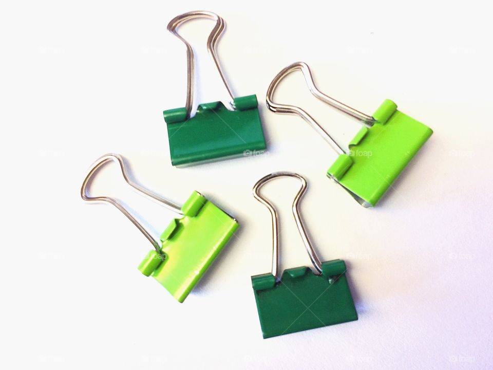 Green binder clips against white background