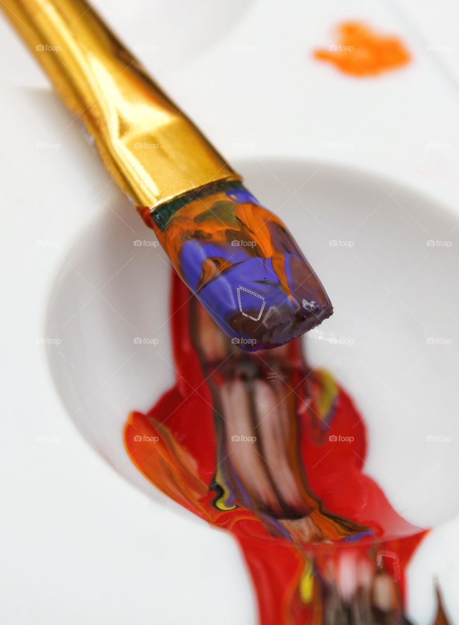 close up photo of paint brush with different colors of paint