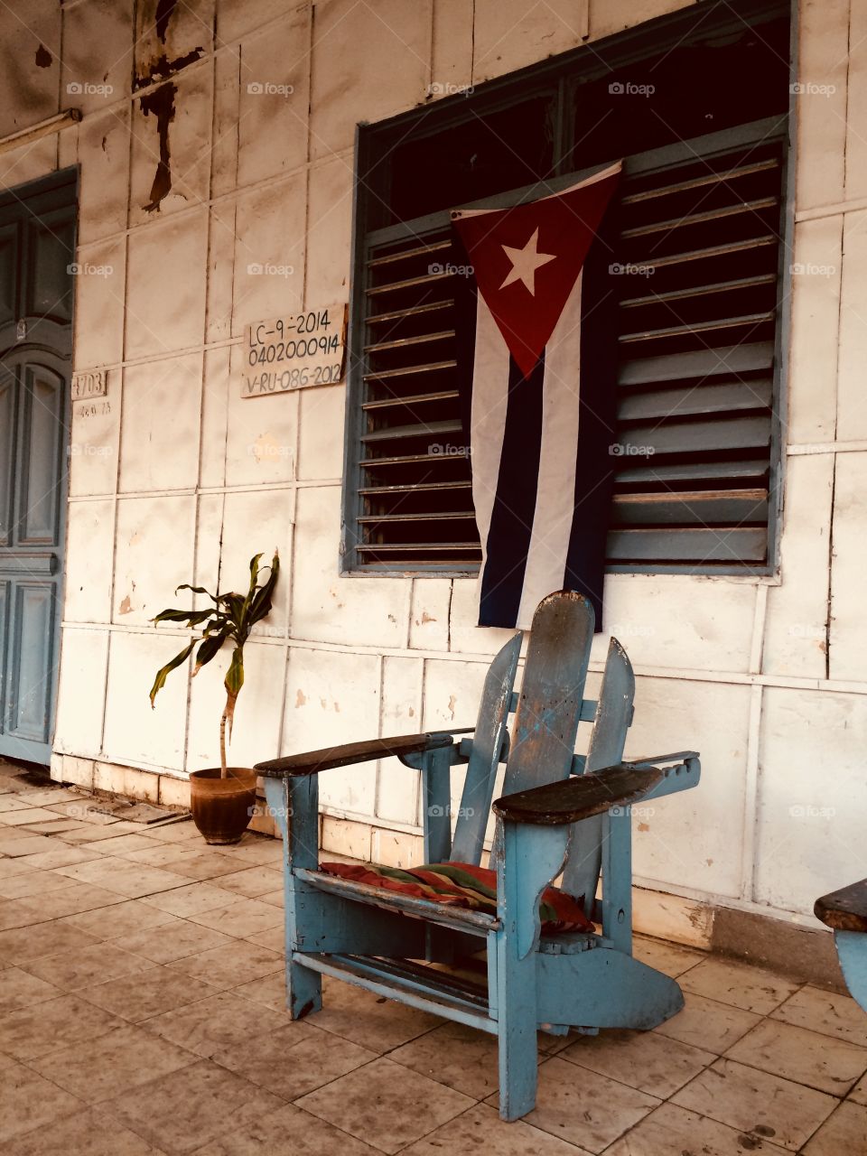 A Street view in Cuba with a chair and a flag