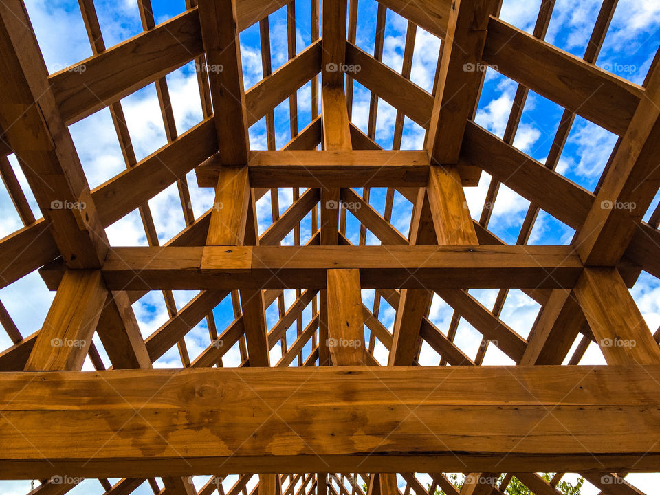 Wooden roof construction under blue sky 