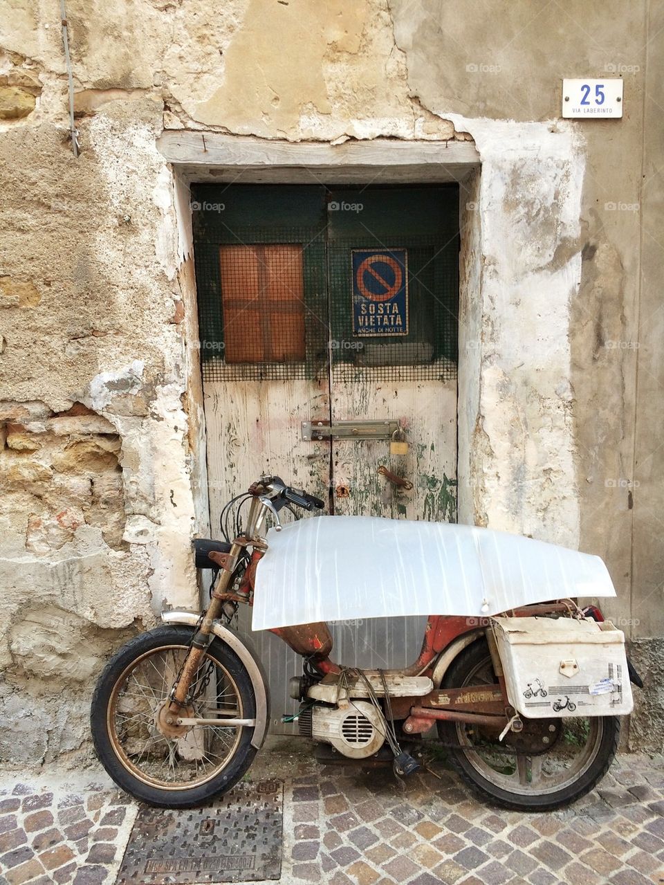 Abandoned old rusty motorbike front of a door