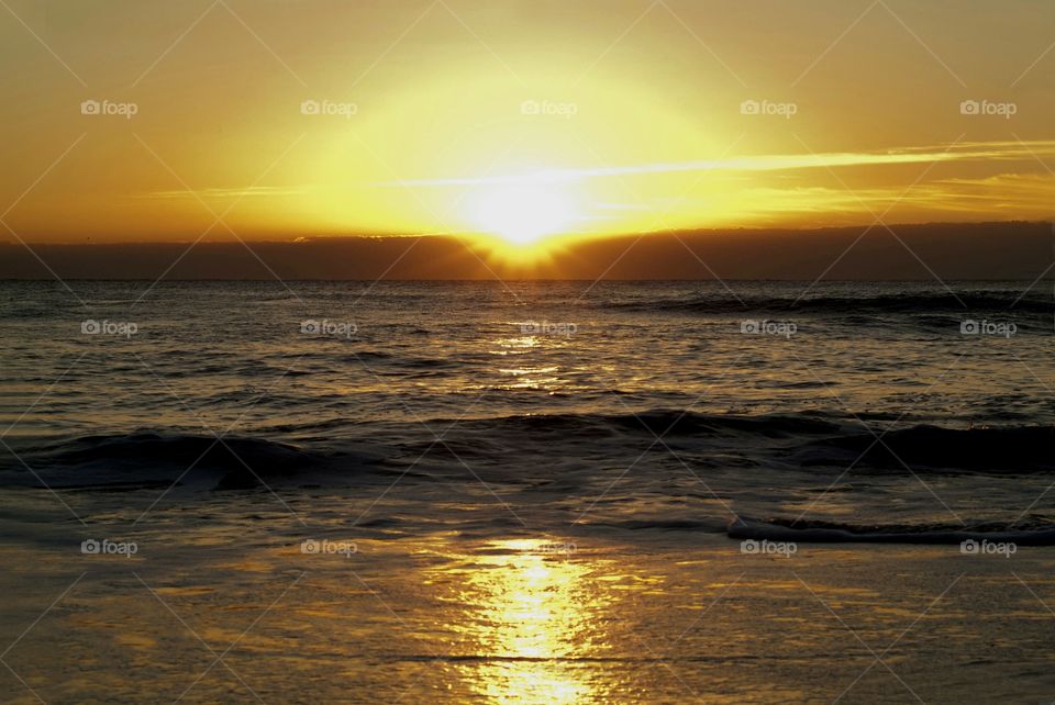 An october sunrise on Virginia beach offers a magnificent morning light show as the sun breaks the horizon