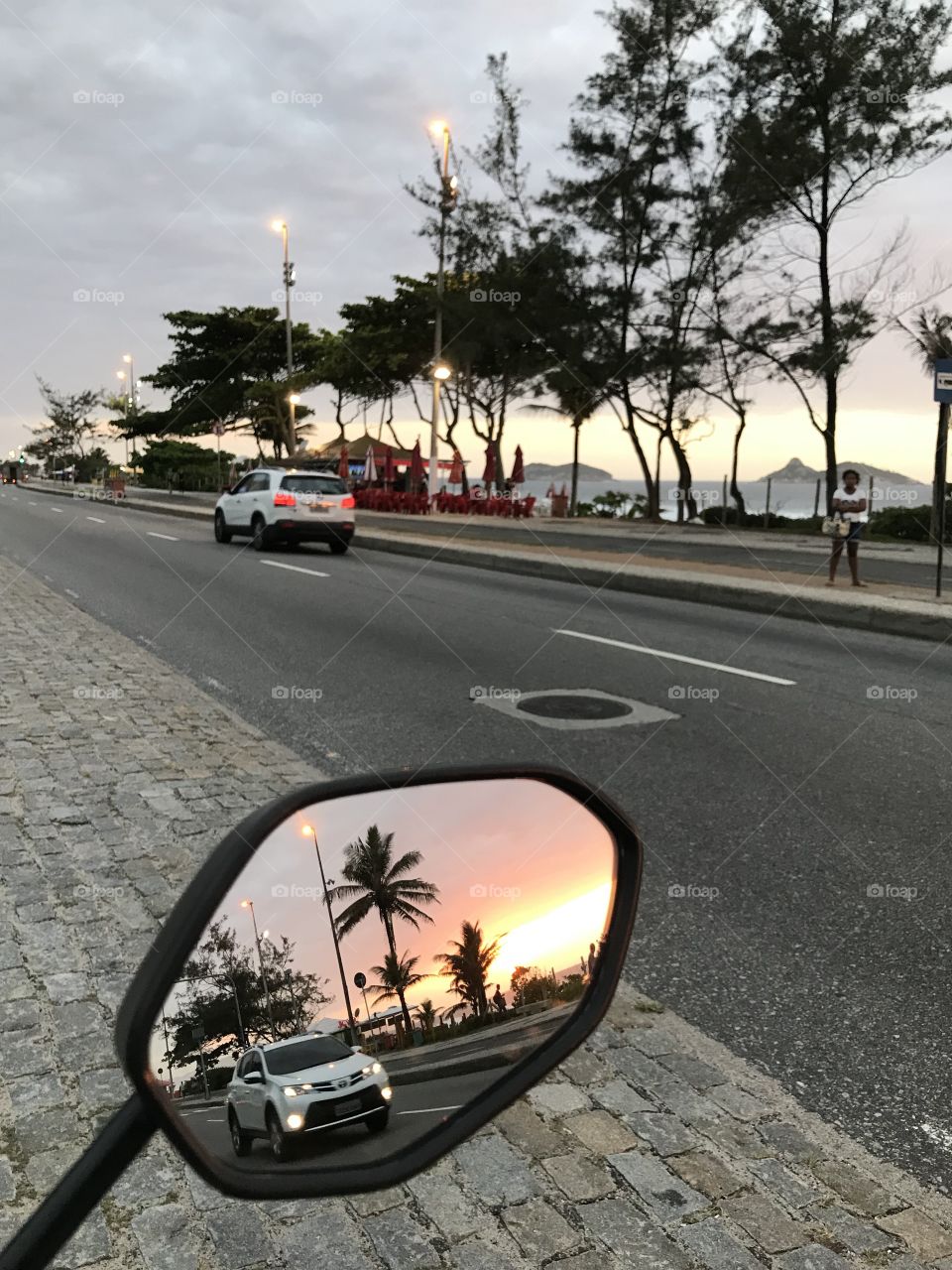 sunset through the motorcycle rearview mirror
