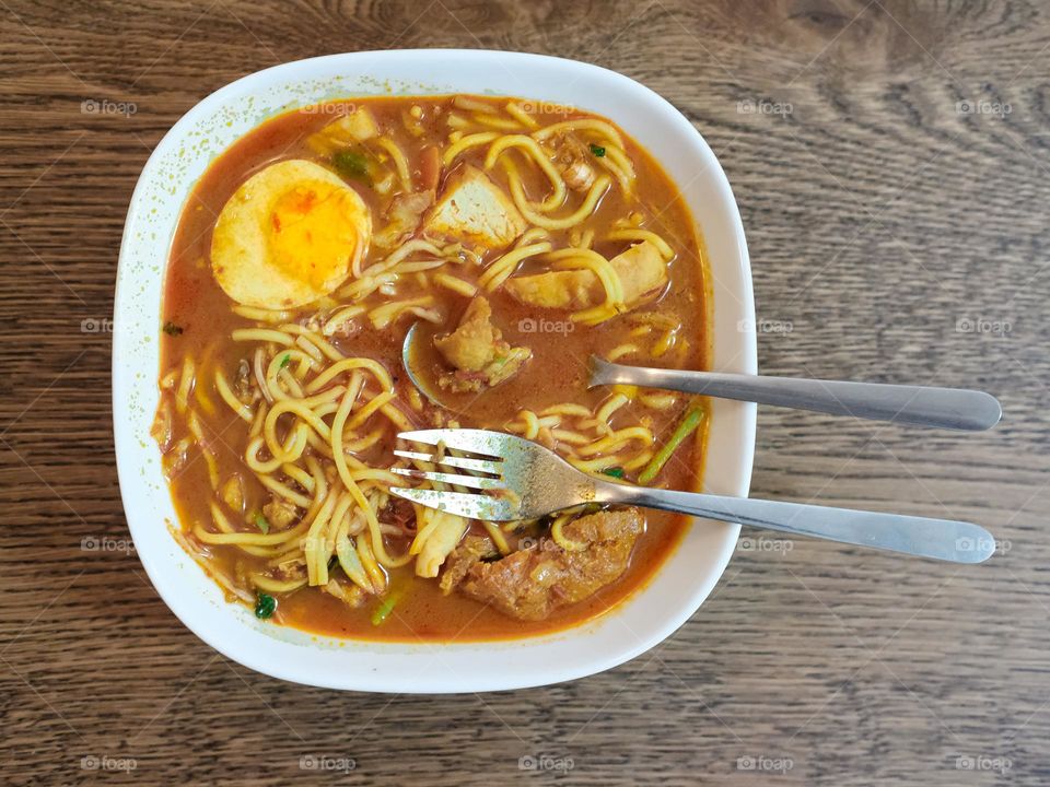 Full frame view of a hot curry noodles in a white ceramic bowl
