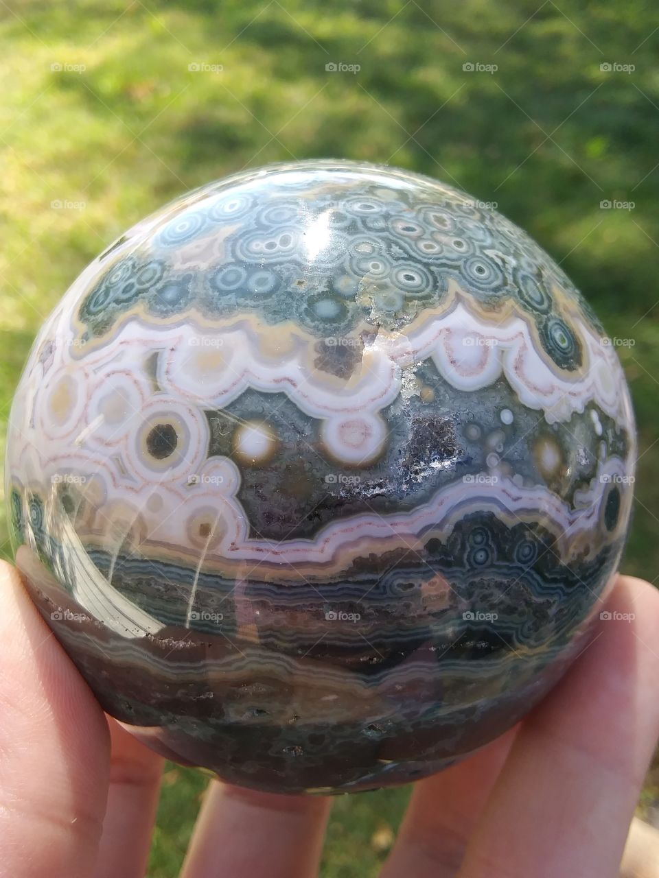 Ocean Jasper Sphere From Madagascar

This is a polished ocean jasper crystal sphere from my personal collection. Ocean Jasper is a mined out mineral. It is the only crystal that combines agate, jasper, and chalcedony into one stone.