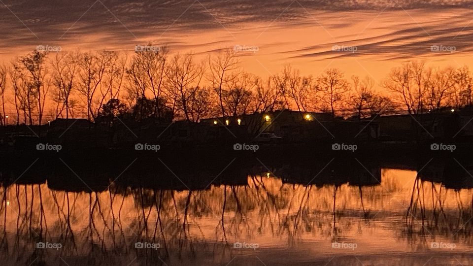 This is a Reflection from Top to Bottom or Top Of Lake Waters. Sunset colors are inviting more from the sunset. Bubbly High thick clouds rest on top of Lake Waters