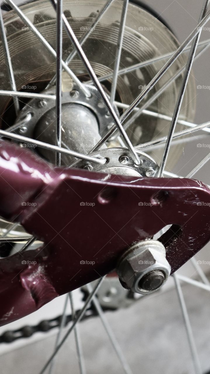 Metal spokes on a bike wheel are shown up close and abstract