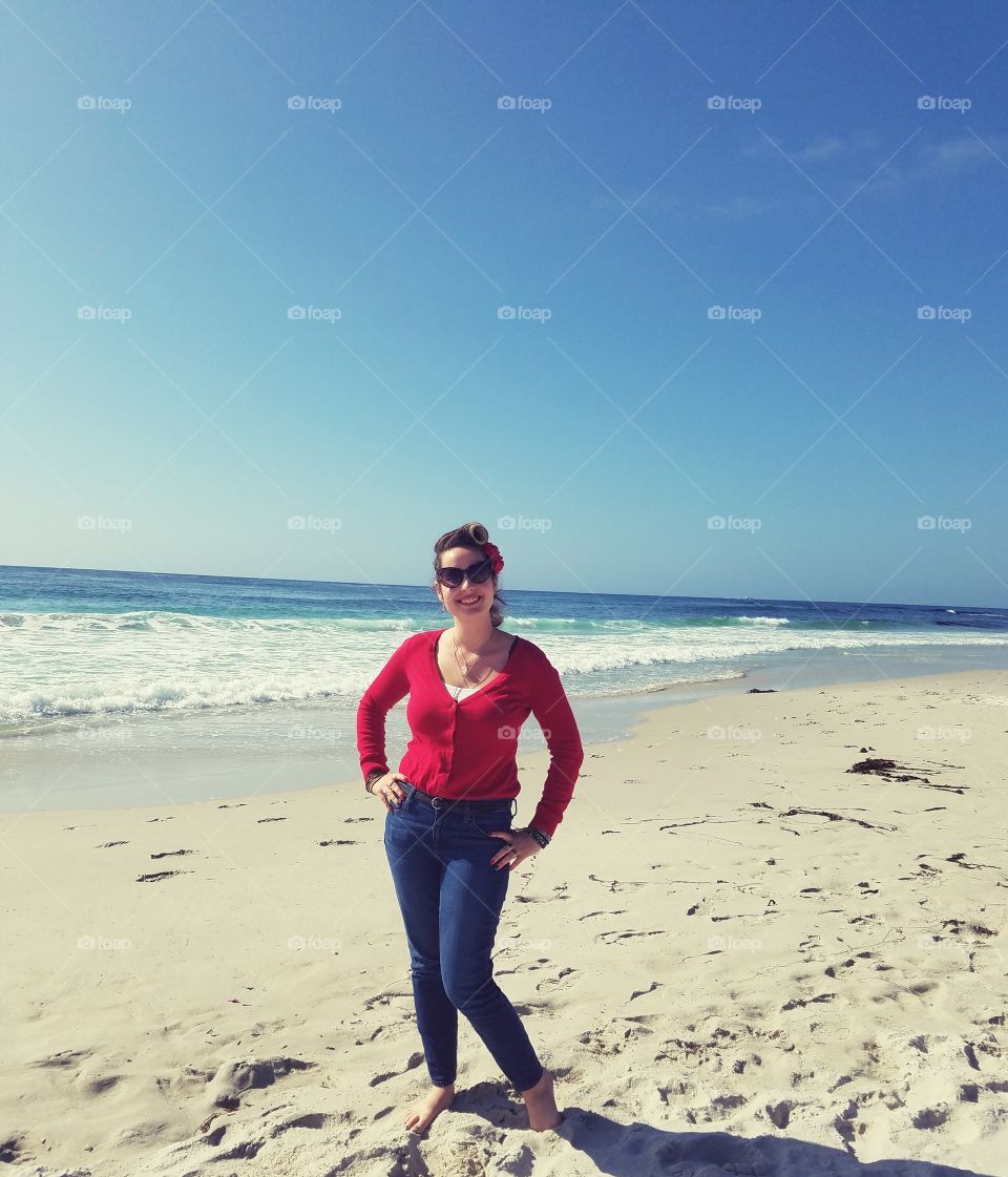 Cute Vintage Retro Rockabilly Girl Posing at the bright Blue Beach on a Sunny Day