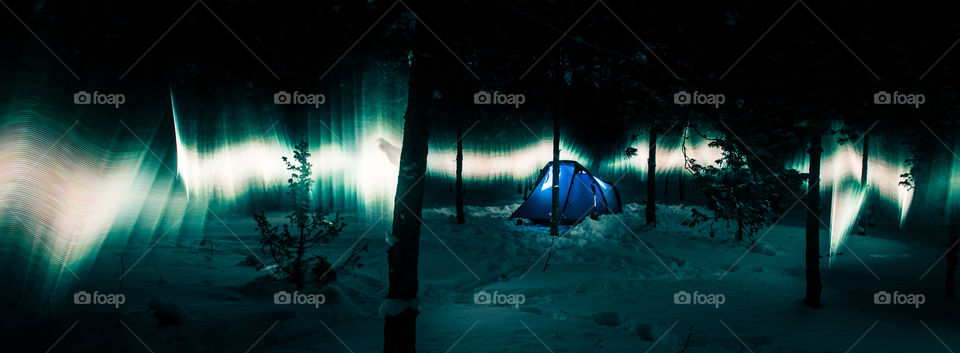 Aurora look alike in the winter forest with tent.