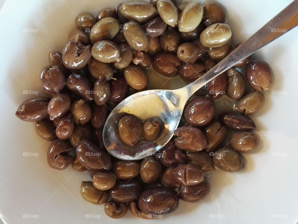 cured semiripe olives in a plate with spoon, Clean Monday