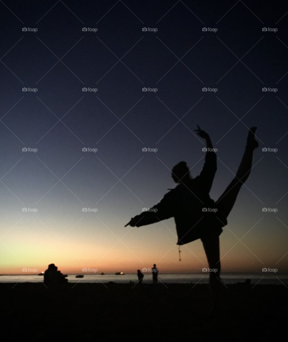 Dancer on Melbourne beach as night falls.