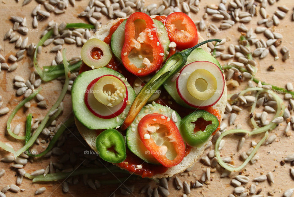 A sandwich with peppers, cucumbers and seeds, spicy