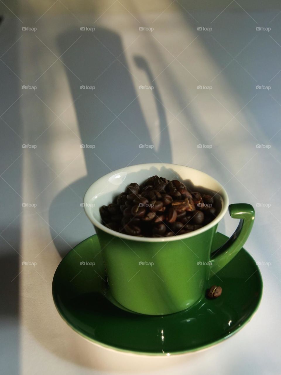 Green cup of coffee beans