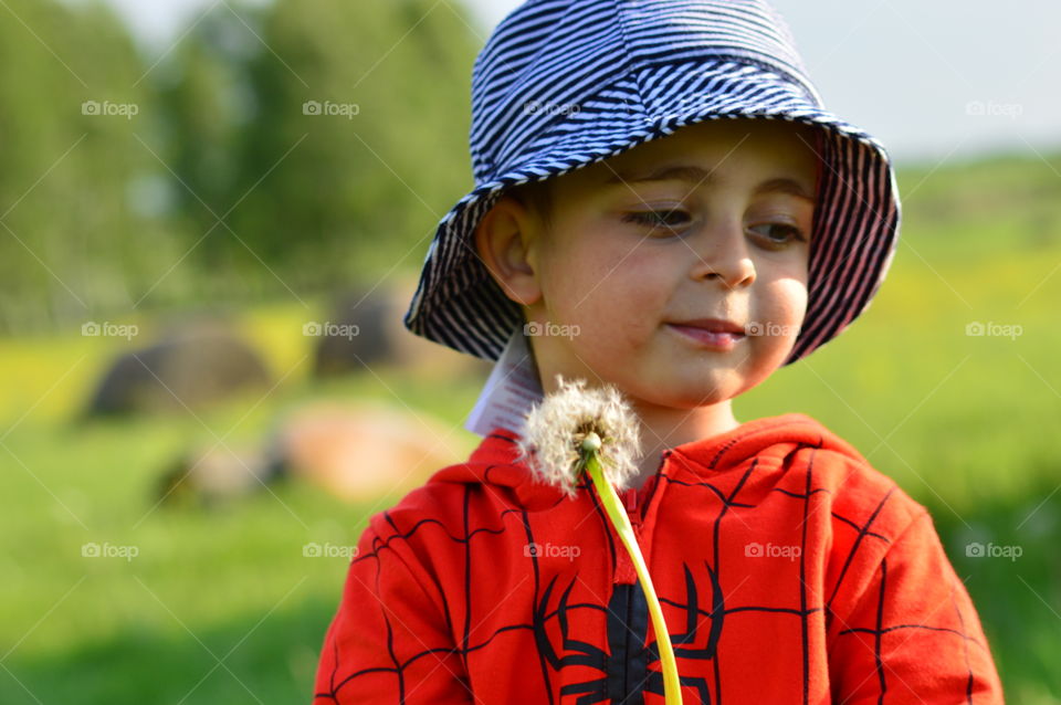 Close-up of cute boy with dandelion