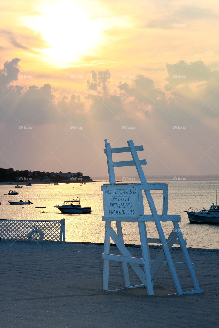 A breathtaking sunset sends sun rays beaming down onto a fleet of sailboats in the Long Island sound.