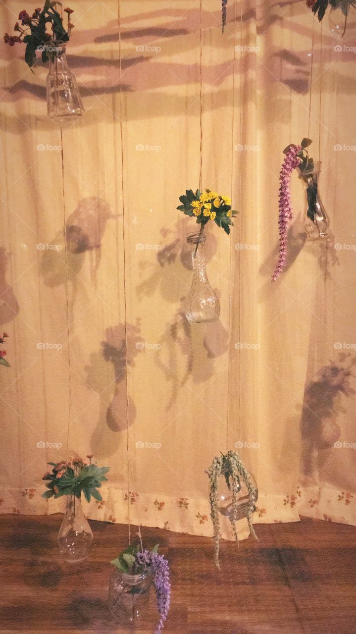 Window display of hanging vases with flowers