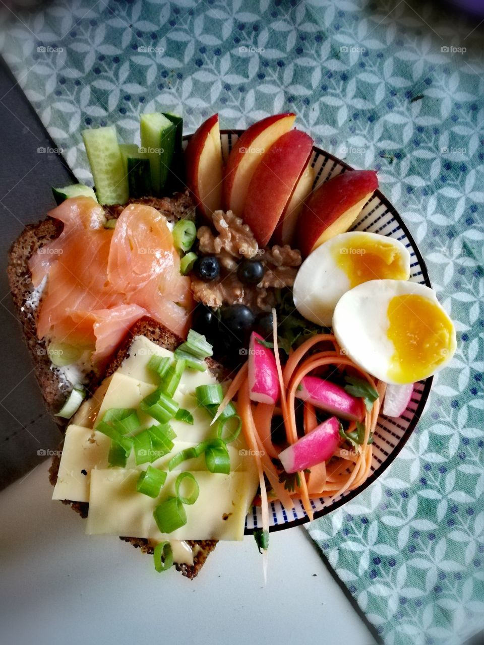 Bowl with a cheese sandwich, salmon, fruit and eggs