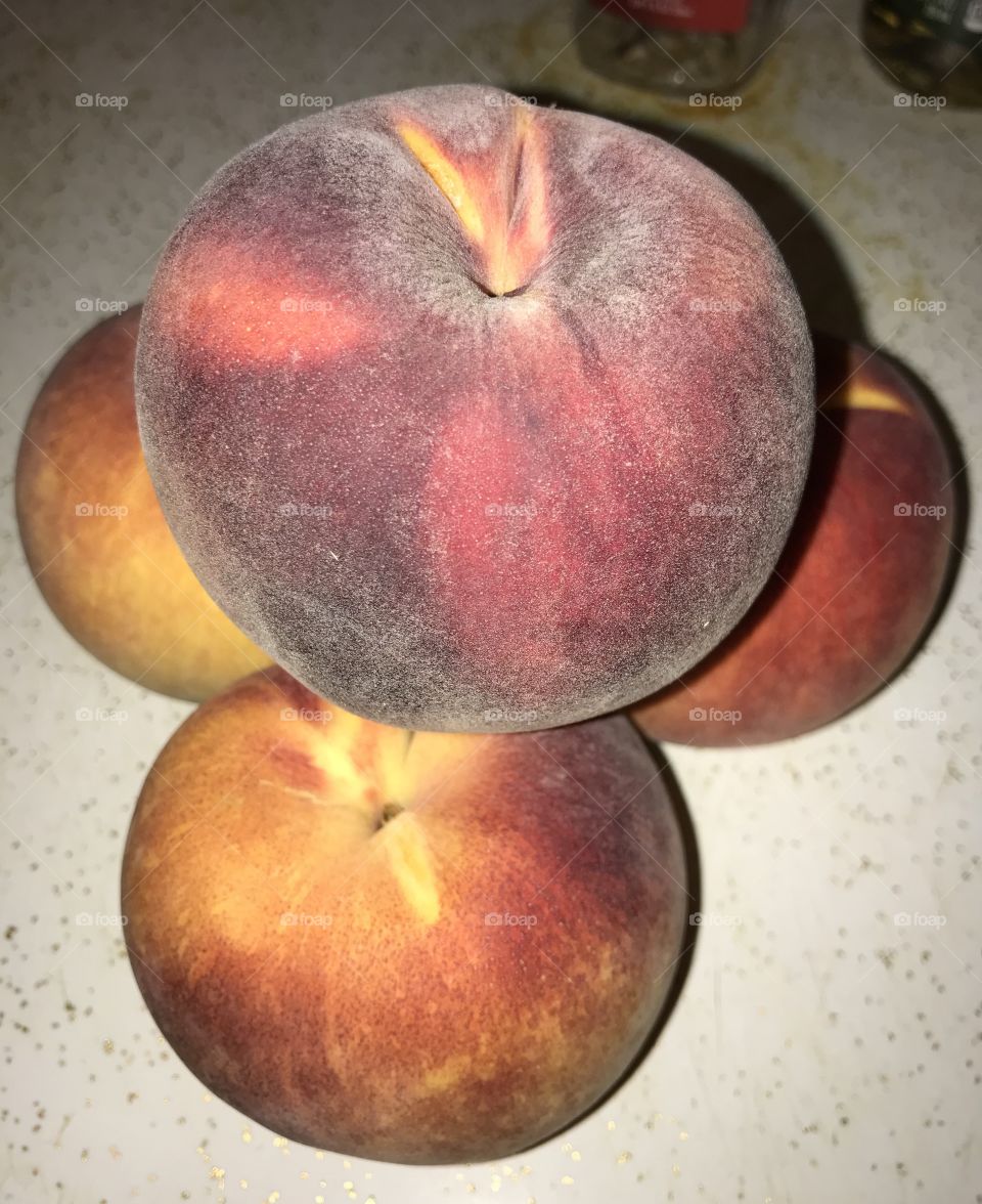 Four peaches forming a hilltop.