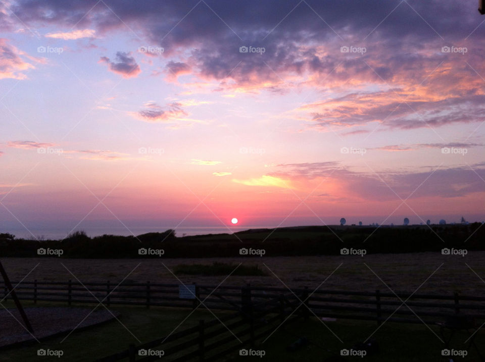 Sun setting over the Cornish coast near Bude with communication dishes