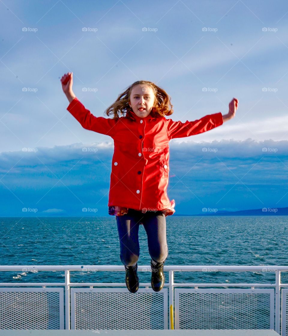 Jumping high - tongue out - on vacation at the seaside 